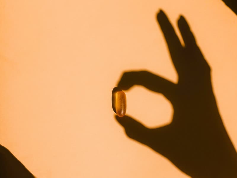 Shadow of a hand projected in such a way that it appears to be holding an omega 3 pill image used in the "Medicare Supplement Plans in 2025: Everything You Need to Know Before You Choose One" article.