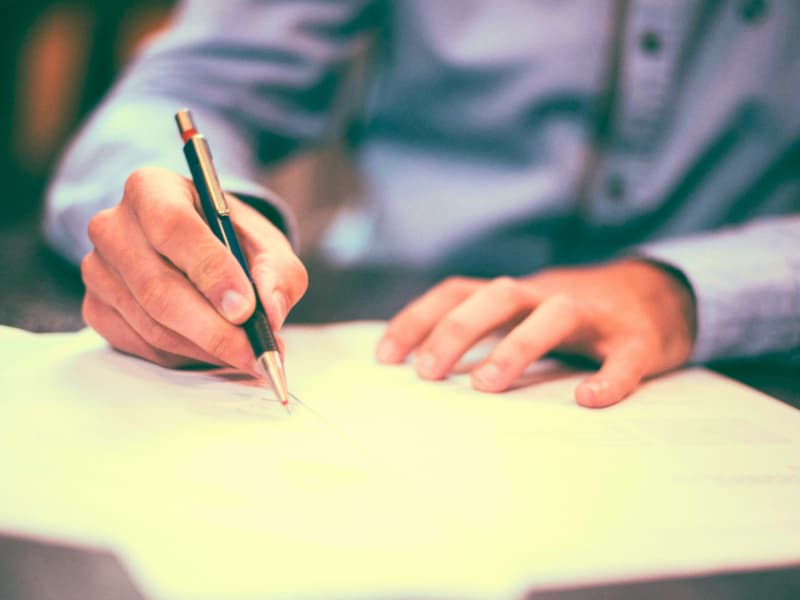 Photo of a hand signing a contract used in a single premium term life insurance of an article of 2025.