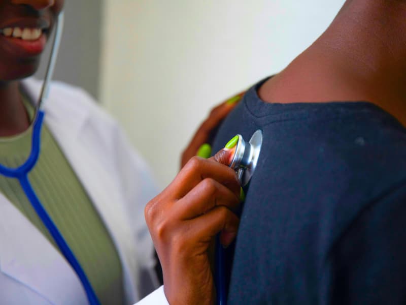A healthcare provider uses a stethoscope during a routine exam, illustrating how preventive visits and Health Insurance Deductibles directly impact early diagnosis and care continuity.