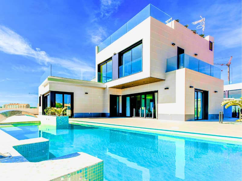 Modern luxury home with glass accents and pool, highlighting the high-value features that directly influence a Homeowners Insurance Quote.