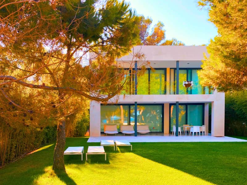 Understanding the Gap: Homeowners Insurance Quotes vs. Your Actual Premium — captured through a contemporary home with full glass walls and open landscaping, where design details often change insurance pricing after evaluation.